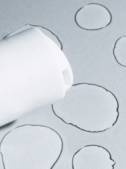Roll of white paper with circular cutouts on a gray background