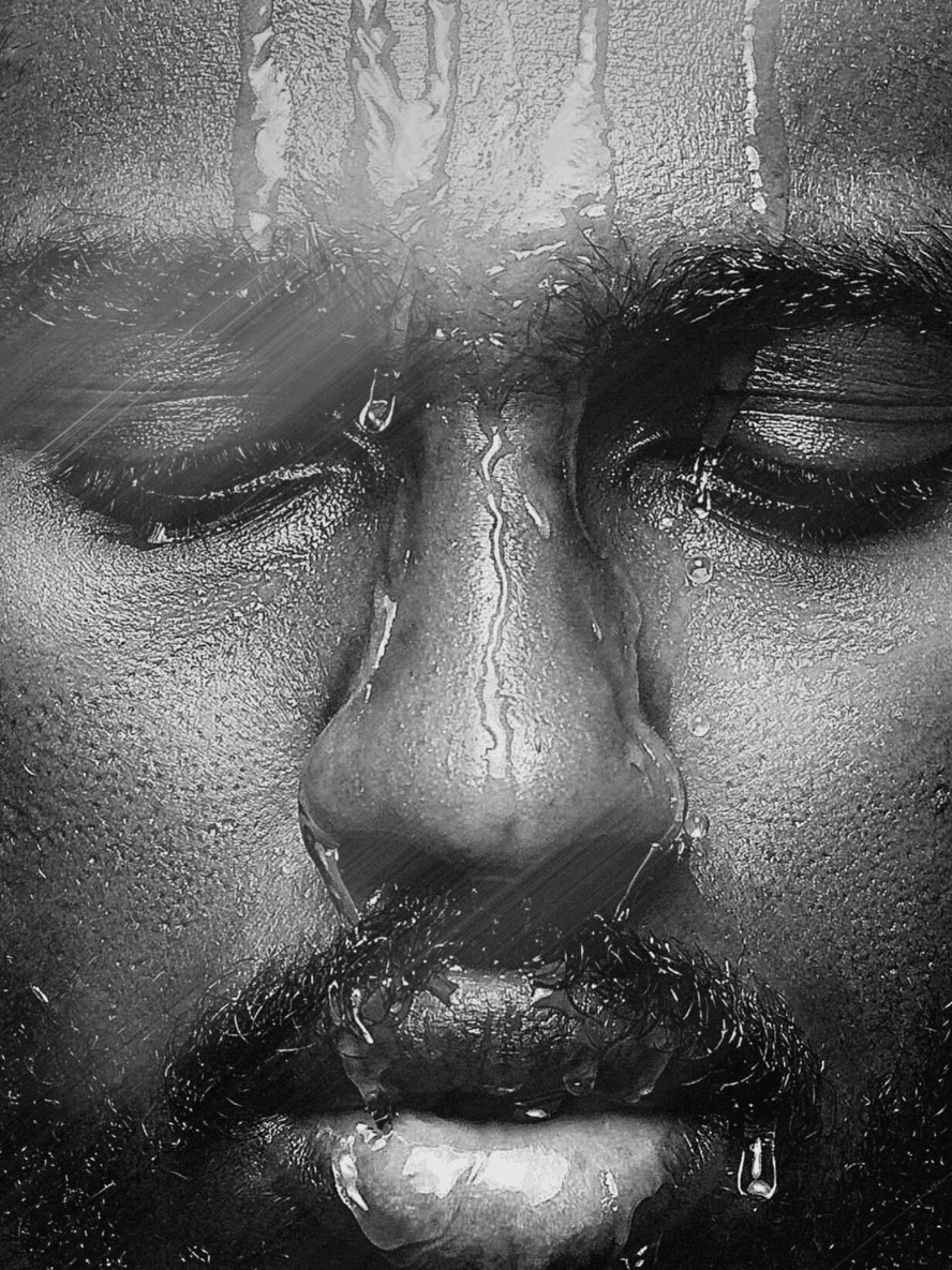Close-up of a person's face with water droplets on a glass surface