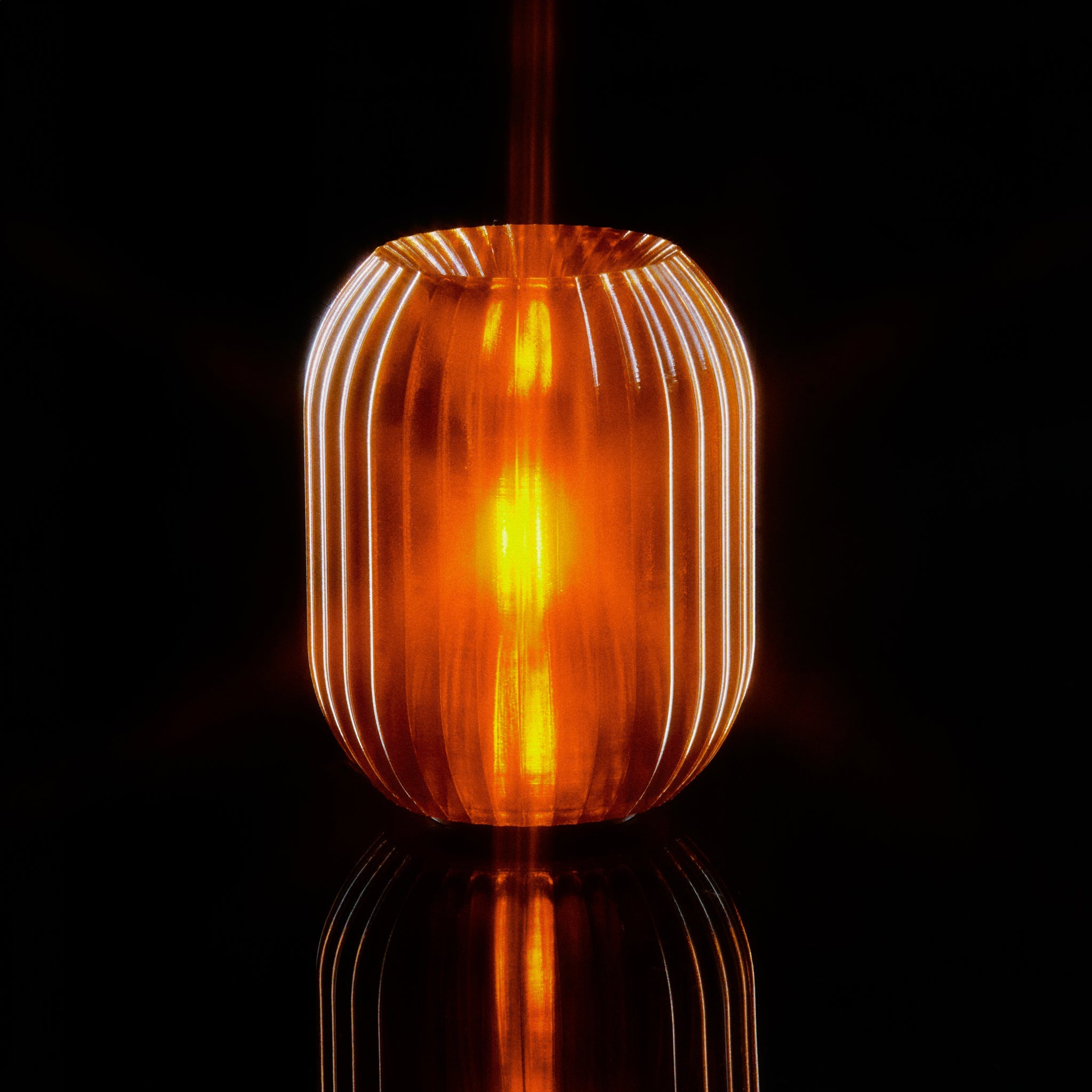 Ornate glass pendant light with ribbed design on a black background