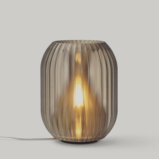 Decorative table lamp with ribbed glass shade on a light gray background