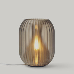 Decorative table lamp with ribbed glass shade on a light gray background
