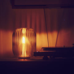 Decorative lamp with a warm glow on a shelf in a dimly lit room