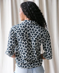 Person wearing a patterned shirt with a neutral background