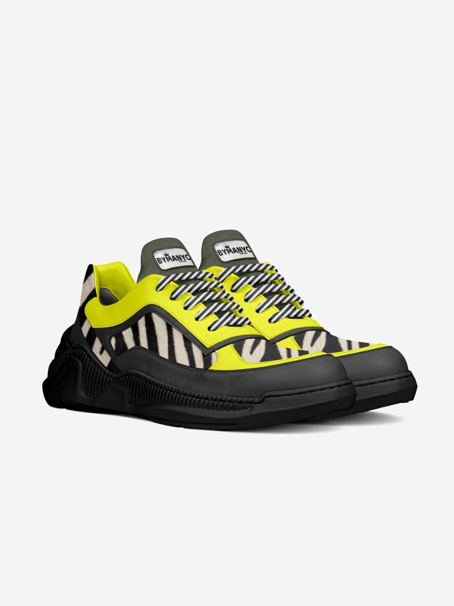 Sneaker with black, yellow, and white pattern on a light gray background