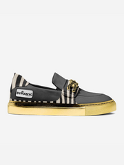 Black loafer with gold sole and striped pattern on a white background