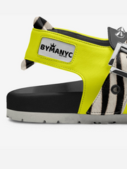 Yellow sandal with zebra pattern sole and 'BYMANYC' label on a white background
