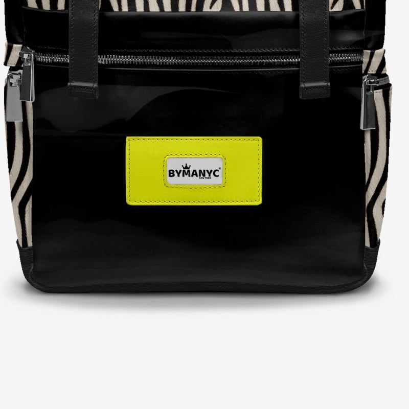 Black backpack with zebra pattern straps and a yellow label on a white background