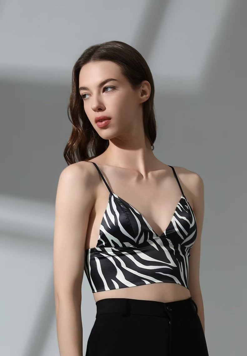 Woman wearing a black and white zebra print top against a gray background