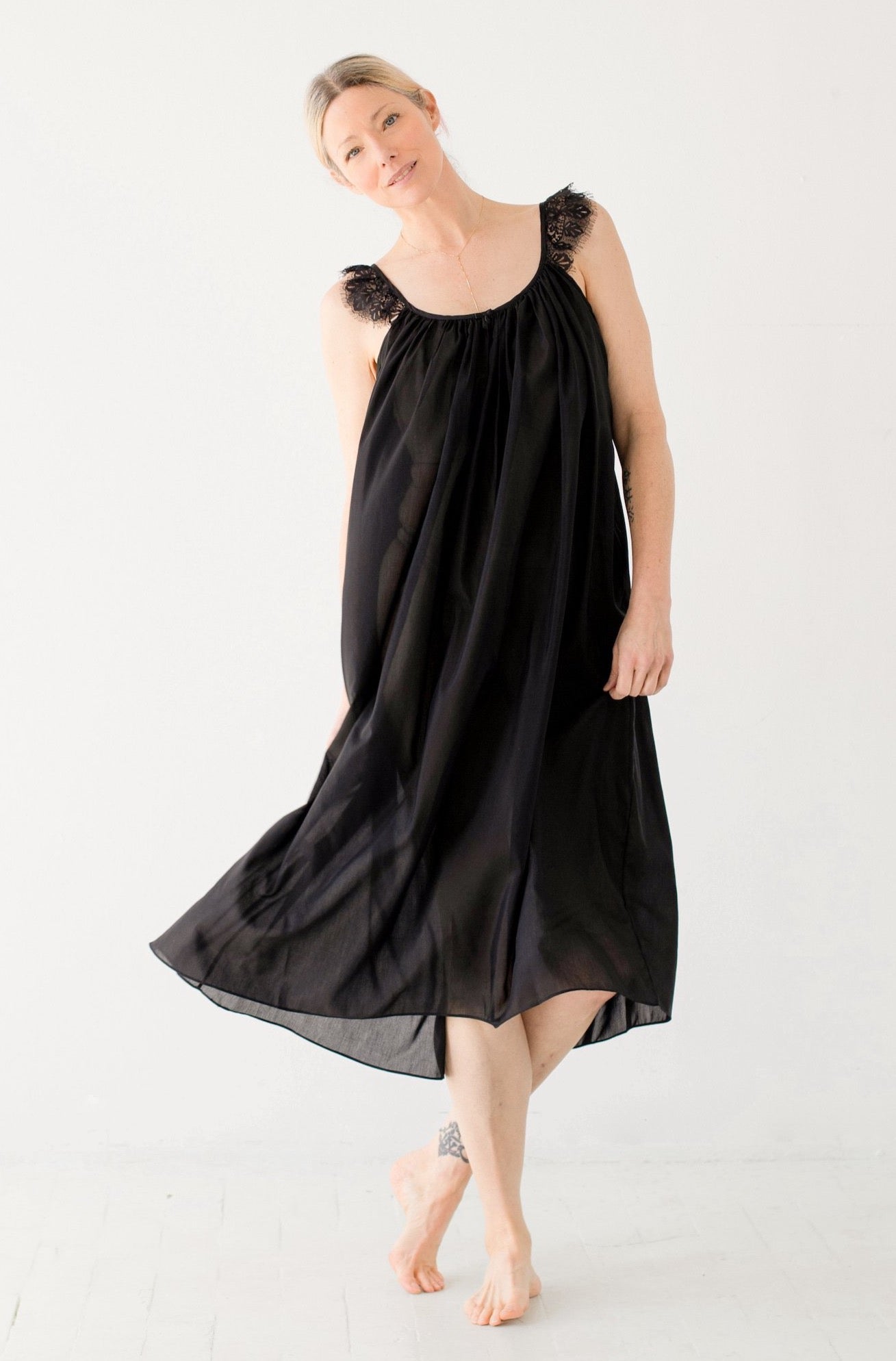 Woman wearing a black dress against a white background