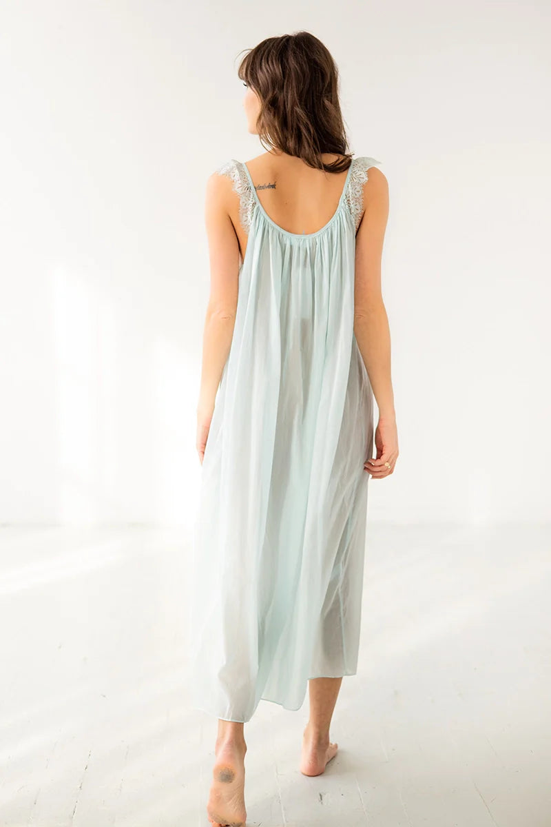 Woman wearing a light blue dress against a white background
