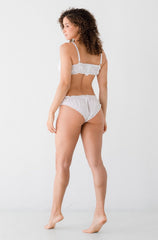 Woman wearing a white bikini set on a plain background