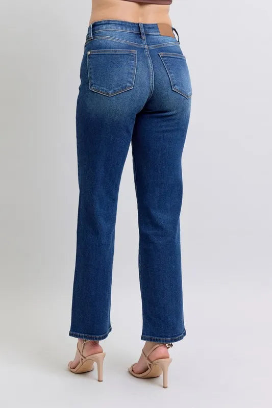 Blue jeans worn by a person on a plain background