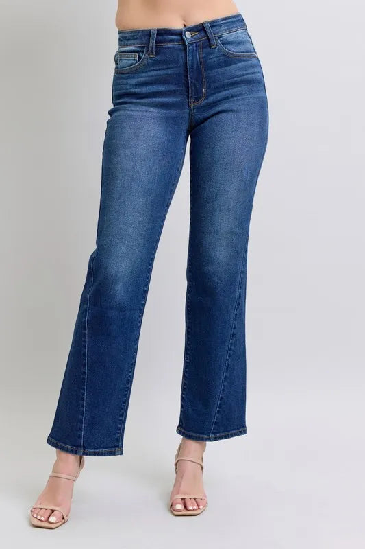 Blue jeans worn by a person on a plain background