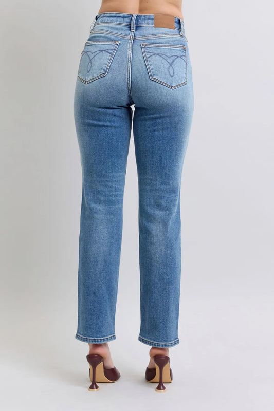 Blue jeans worn by a person on a plain background