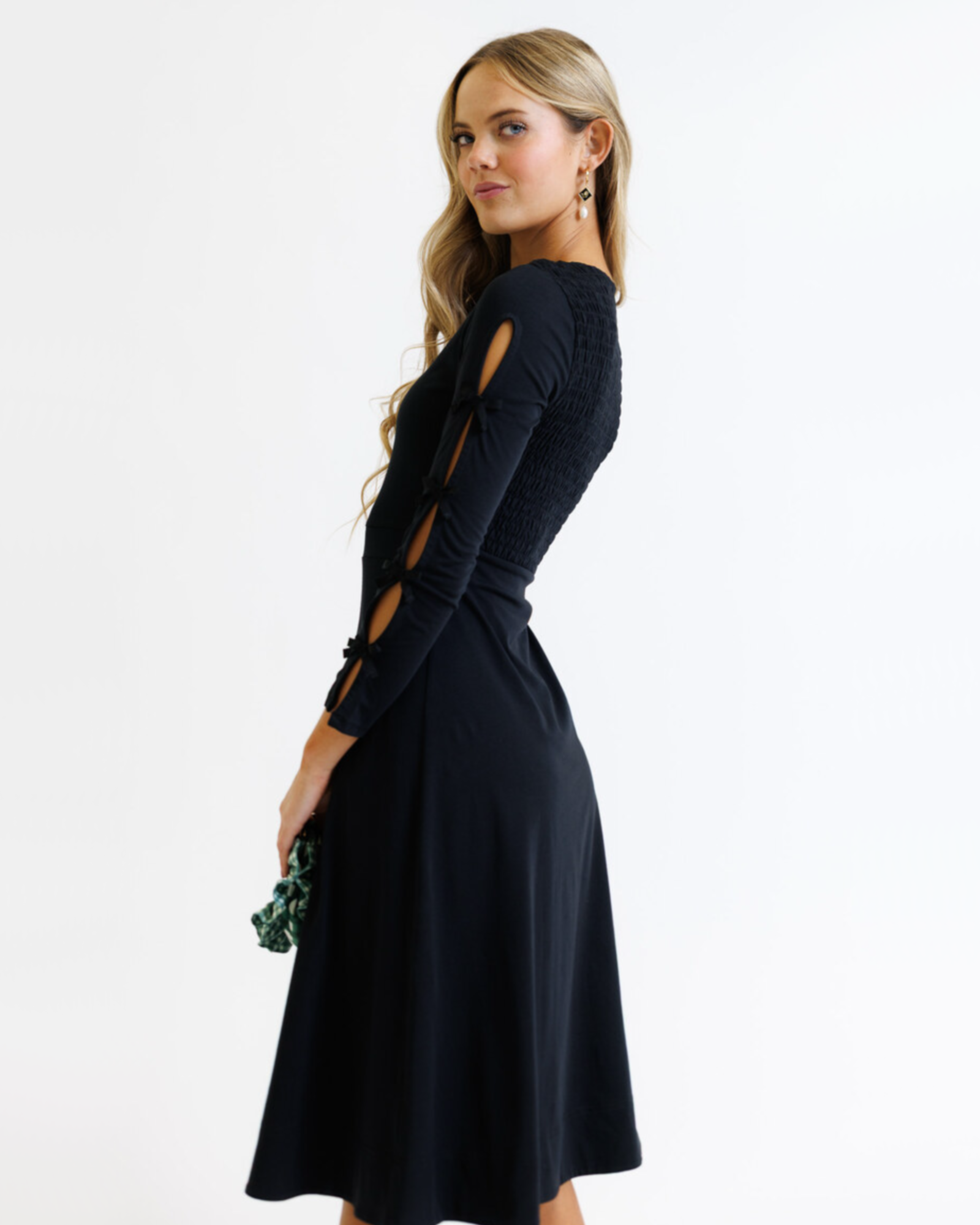 Woman wearing a black dress with cut-out design on a white background