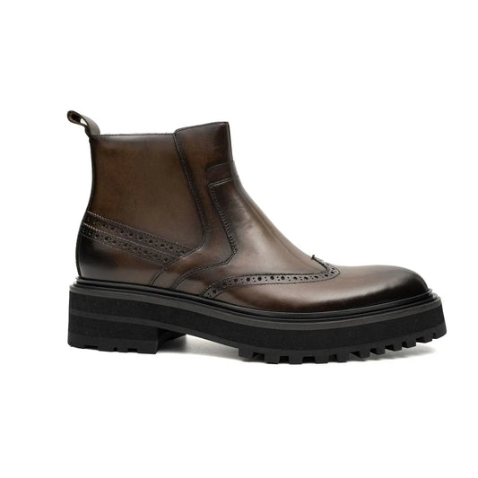 A dark brown leather ankle boot with a chunky black lug sole and brogue detailing, shown from a side profile on a white background.