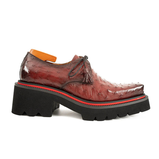 Brown leather shoe with a thick black sole on a white background