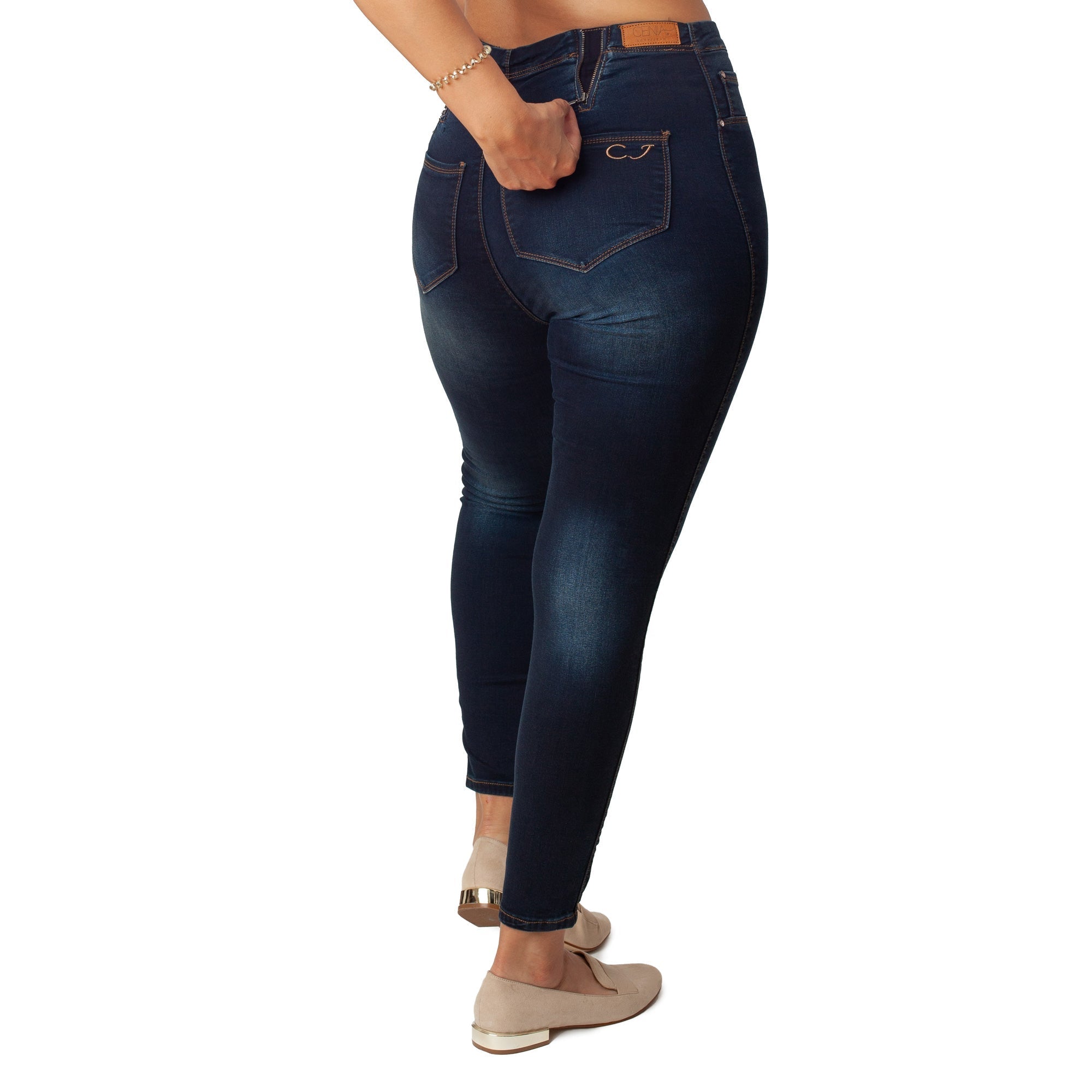 Dark blue jeans worn by a person on a white background