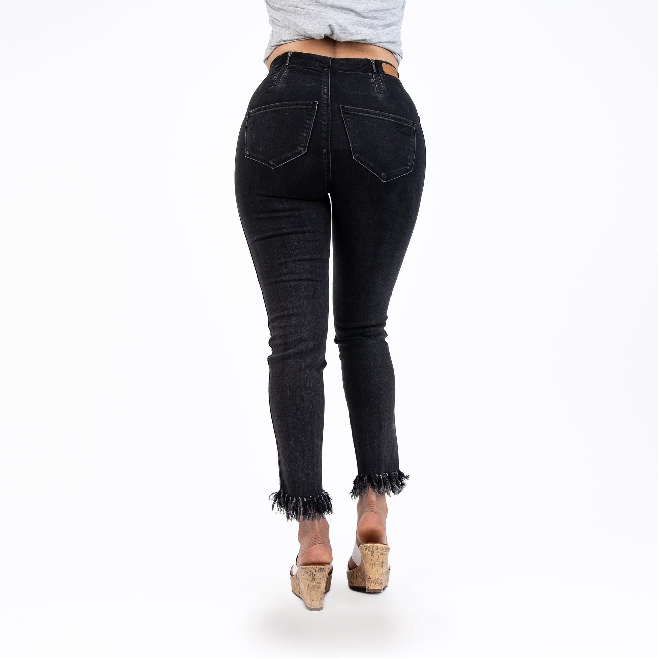 Person wearing black jeans on a white background