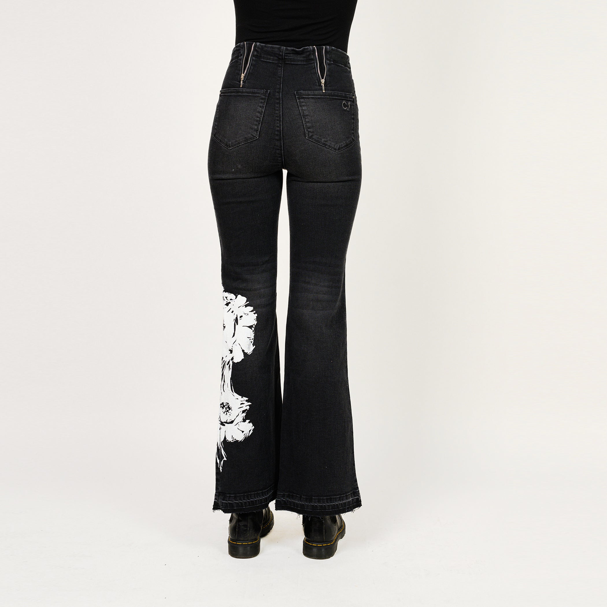 Black flared jeans with white floral design on a white background