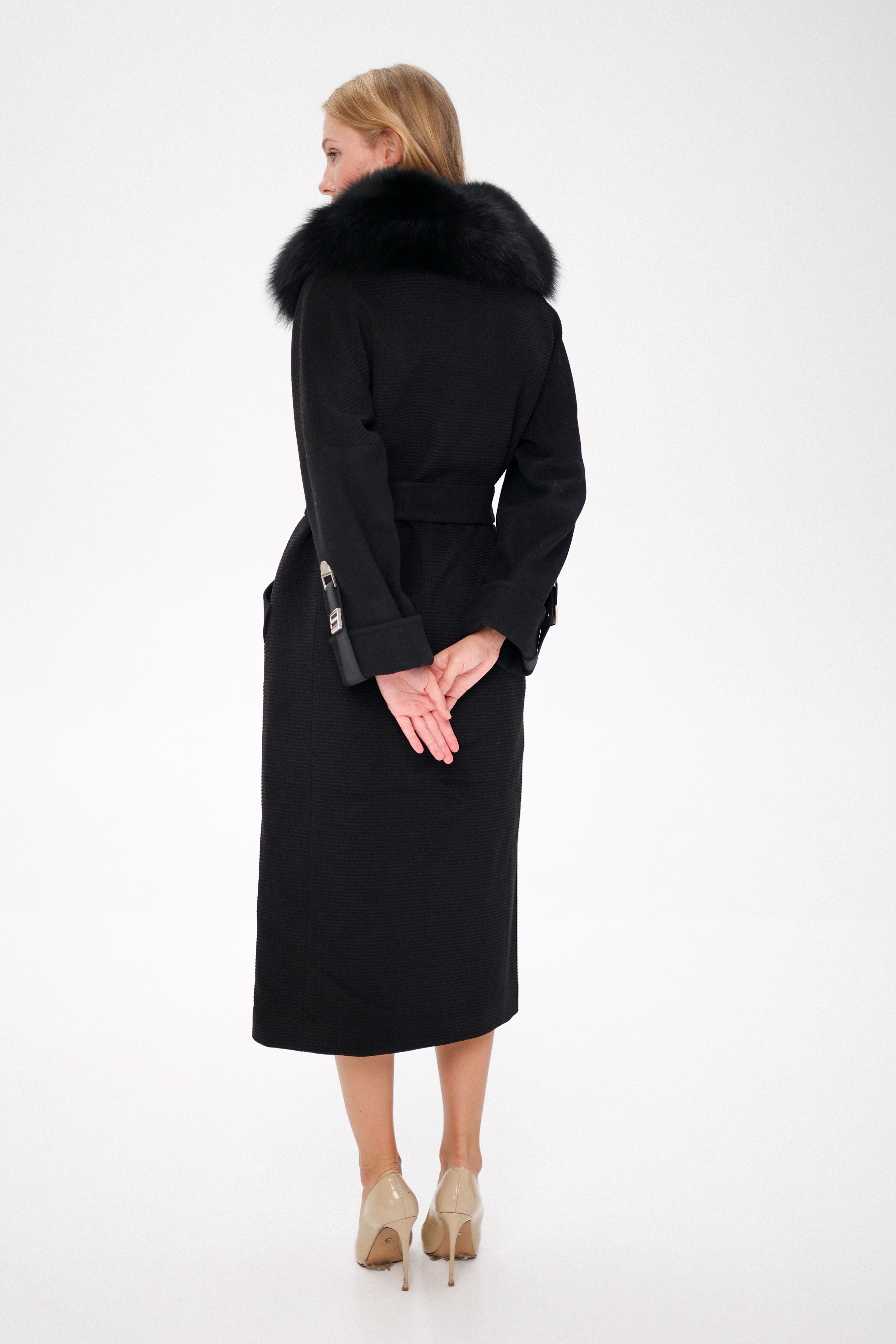 Woman wearing a black coat with fur collar on a white background