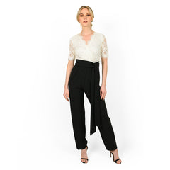 Woman wearing a white lace top and black high-waisted pants on a white background