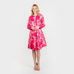 Woman wearing a pink floral dress on a white background