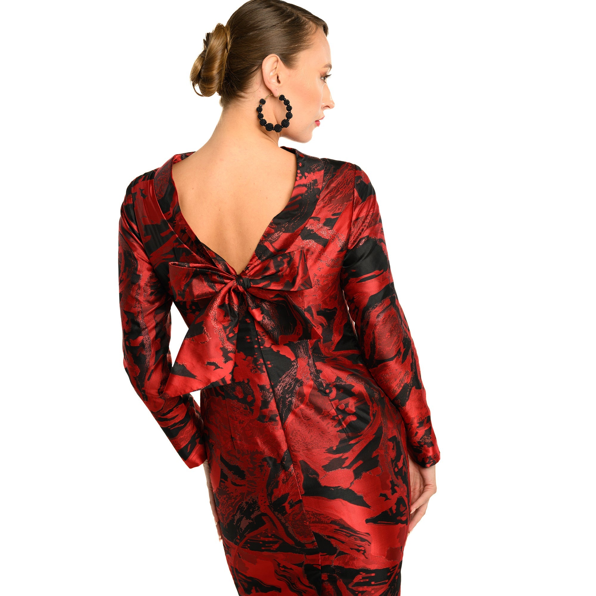 Red and black patterned dress worn by a model on a white background