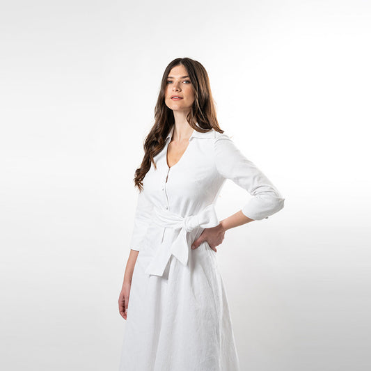 Woman wearing a white dress with a belt on a white background