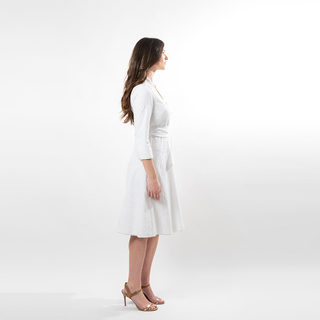 Woman wearing a white dress on a plain background