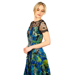 Woman wearing a colorful dress with black lace details on a white background