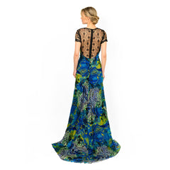 Woman wearing a blue and green patterned dress with a black lace top on a white background