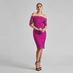 Woman wearing a pink lace dress against a gray background