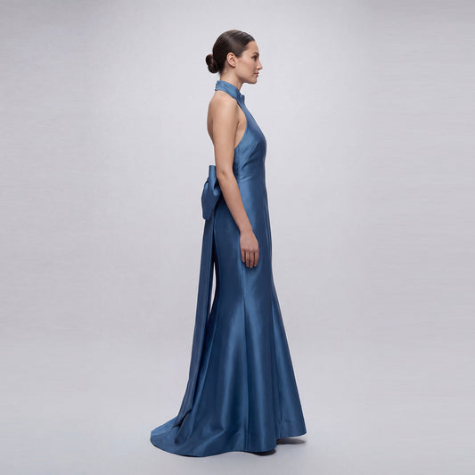Woman wearing a blue evening gown on a plain background