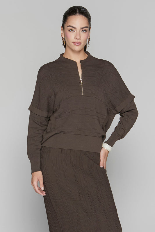 Woman wearing a brown outfit against a plain background