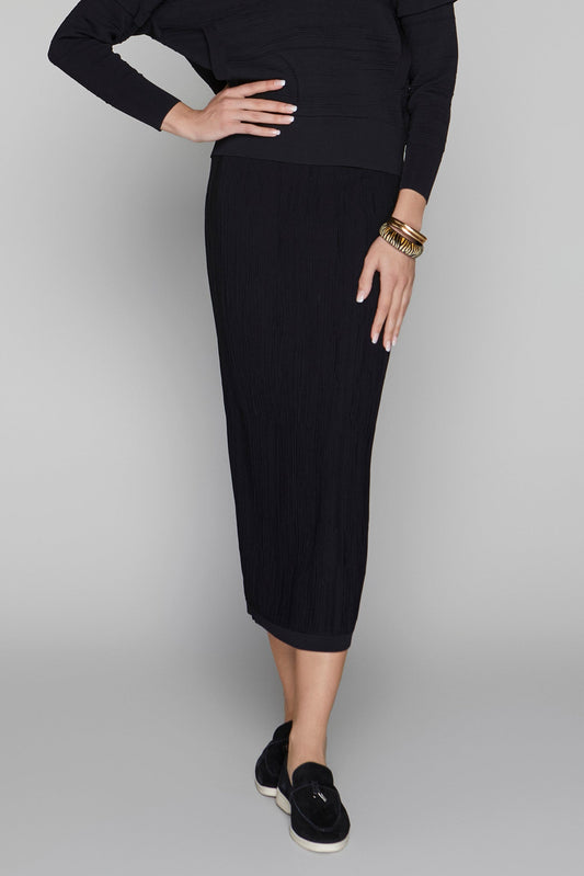 Person wearing a black outfit with a skirt on a gray background