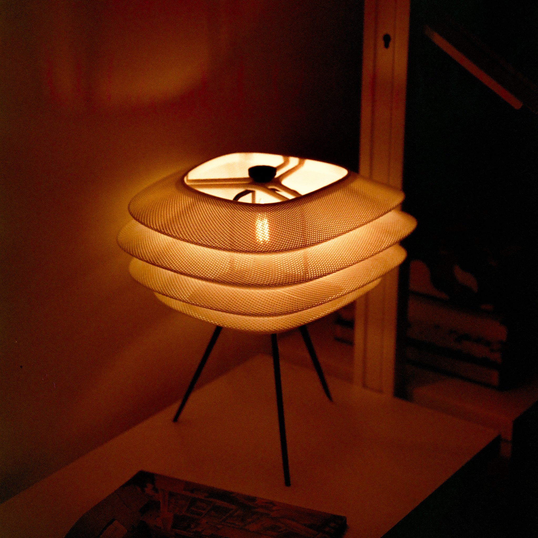 Woven lamp on a stand in a dimly lit room