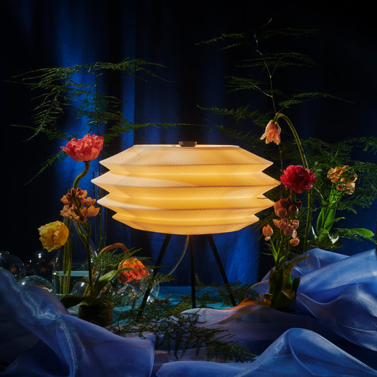 Decorative lamp with flowers and blue fabric in a dark setting