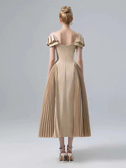 Beige dress with ruffled shoulders on a plain background