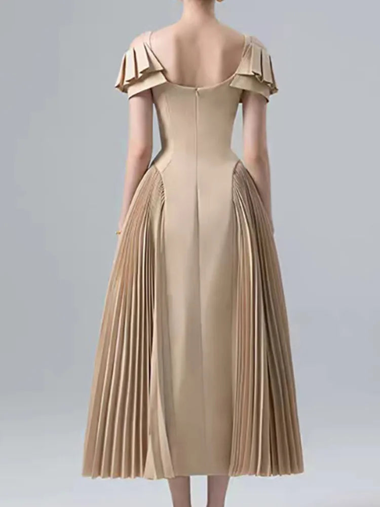 Beige dress with ruffled shoulders on a gray background