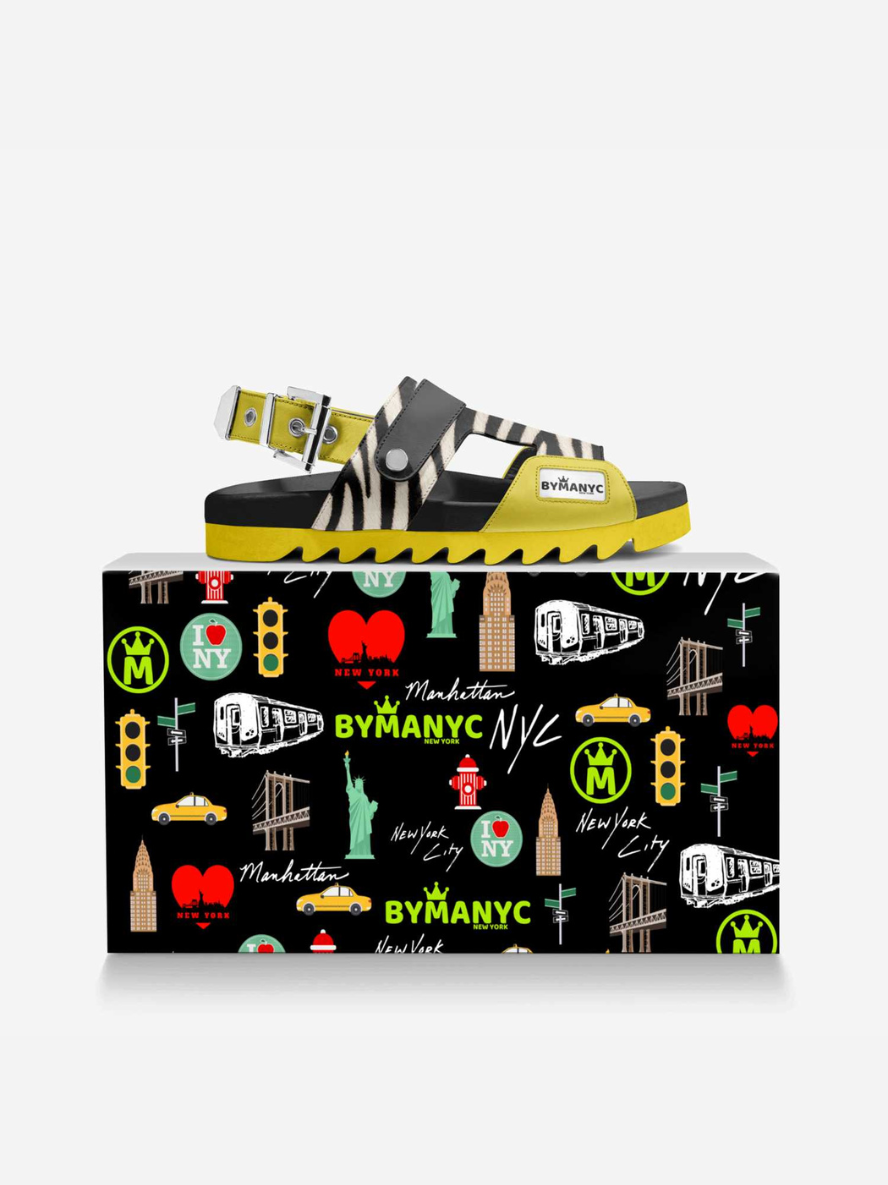 Shoe with colorful design on a matching box featuring New York City-themed illustrations.