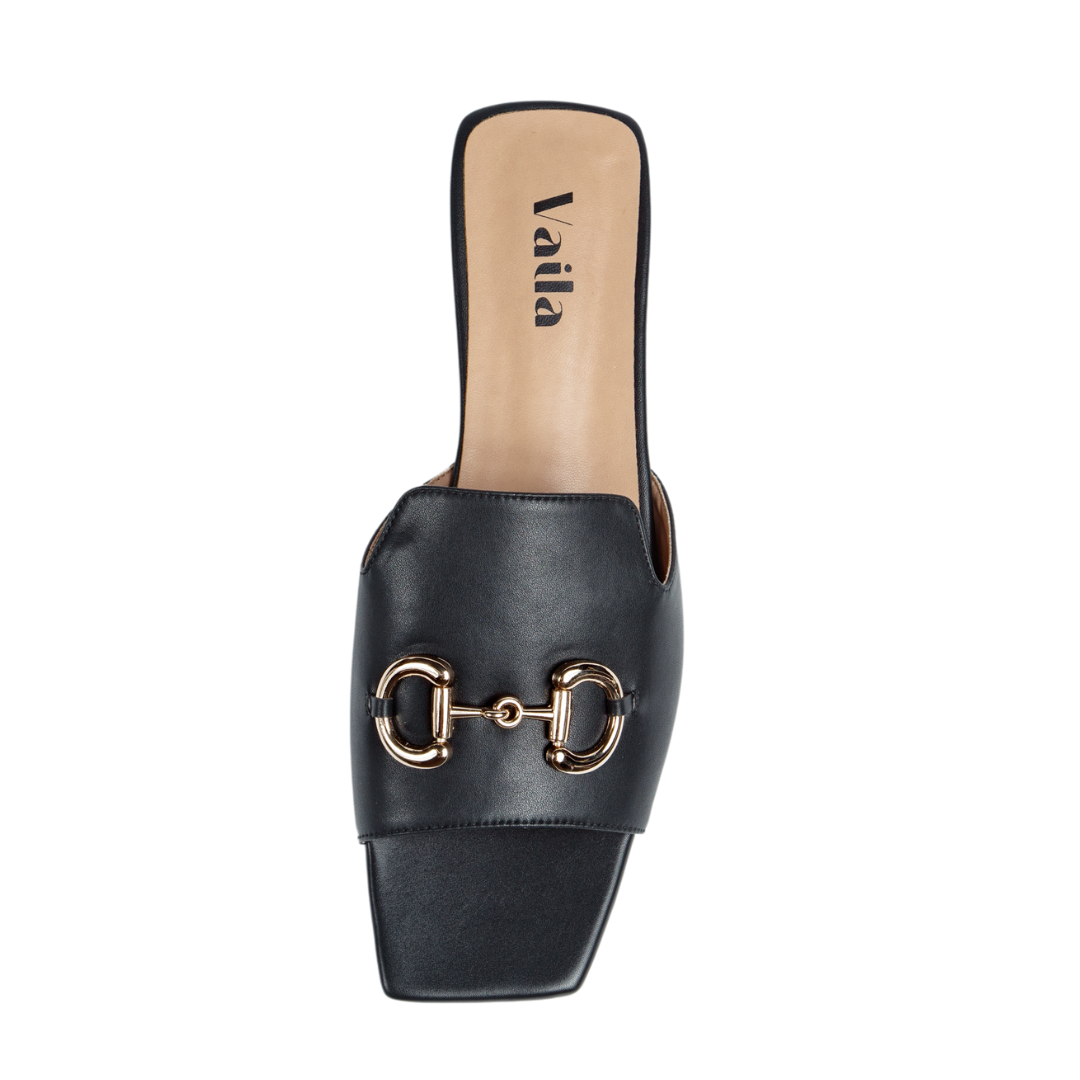 Black slide sandal with gold buckle detail on a white background