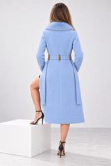 A woman shown from the back wearing a light blue knee-length coat with a fur-trimmed collar and a brown belt, standing on a white pedestal in a studio setting.