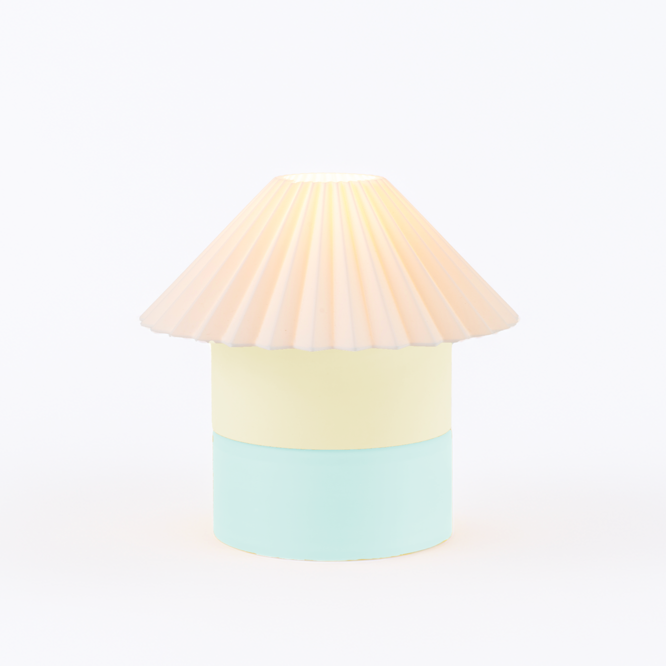 Pastel-colored lamp with a pleated shade on a white background