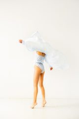 Person holding a large white pillow against a white background