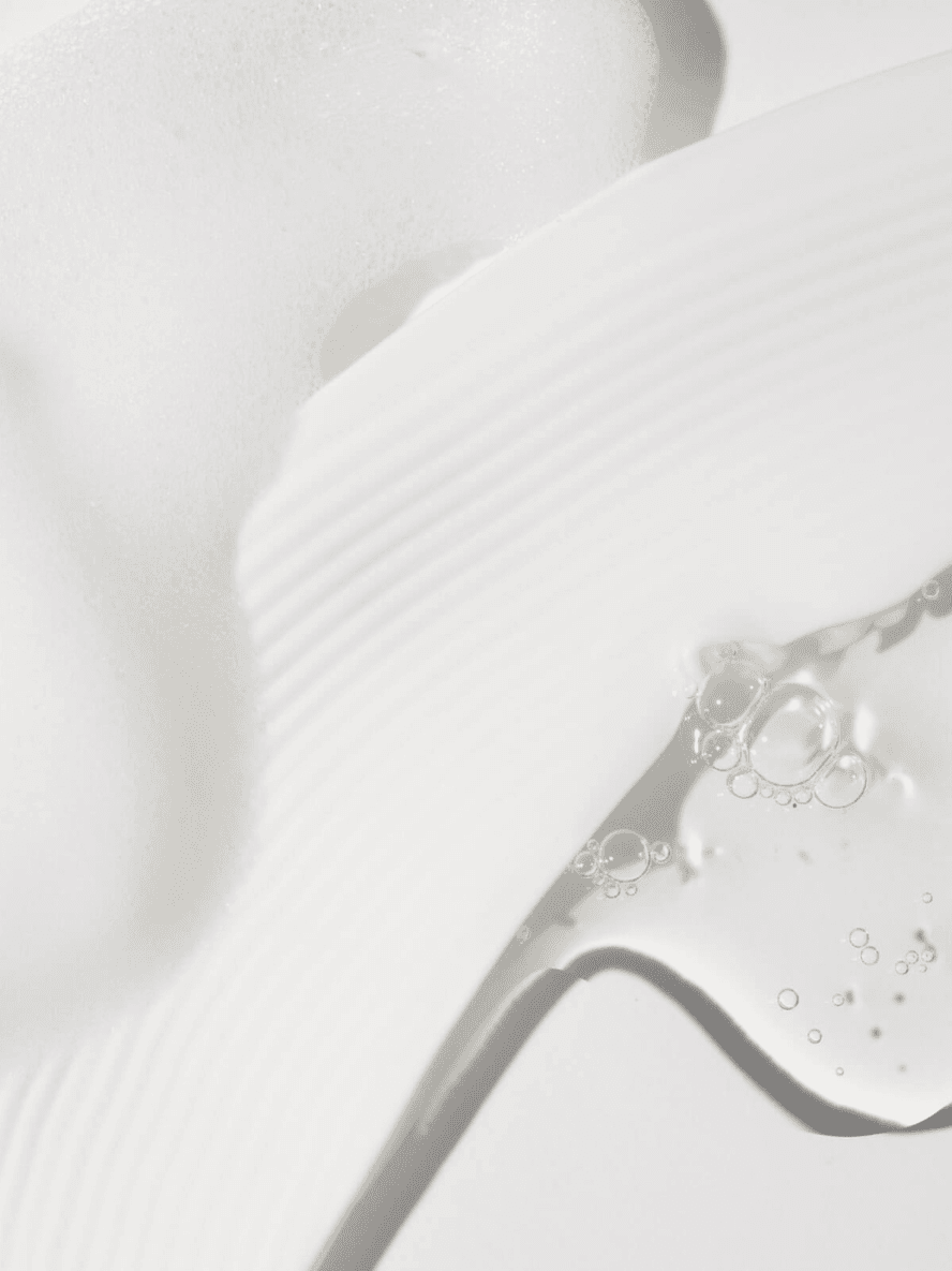 Close-up of a white shoe with a glossy finish on a light gray background