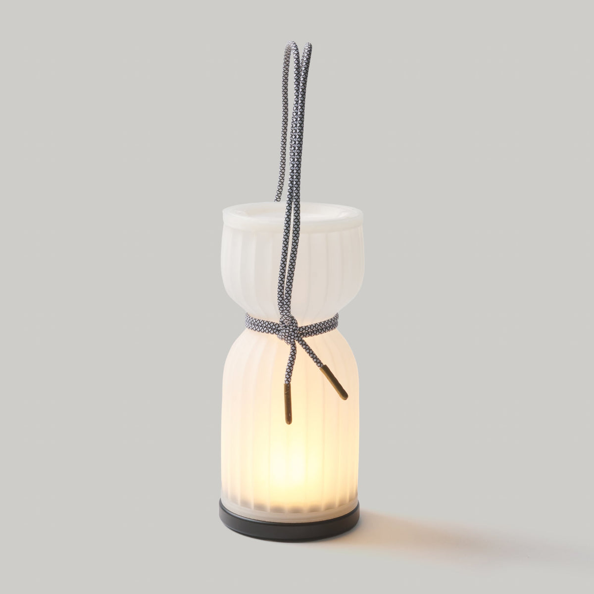 Ceramic lantern with a light inside on a gray background