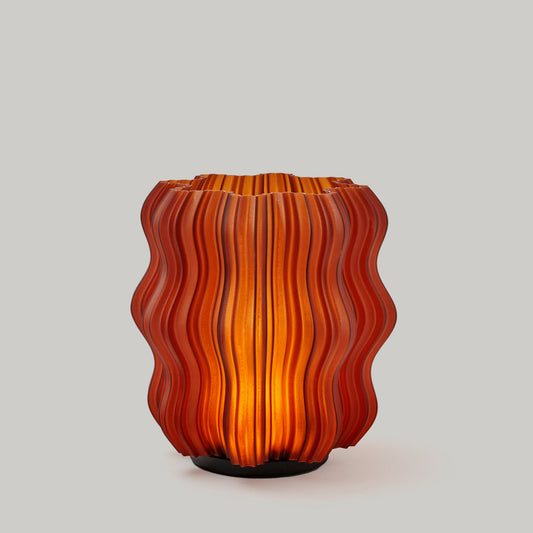 Orange glass vase with wavy pattern on a light gray background