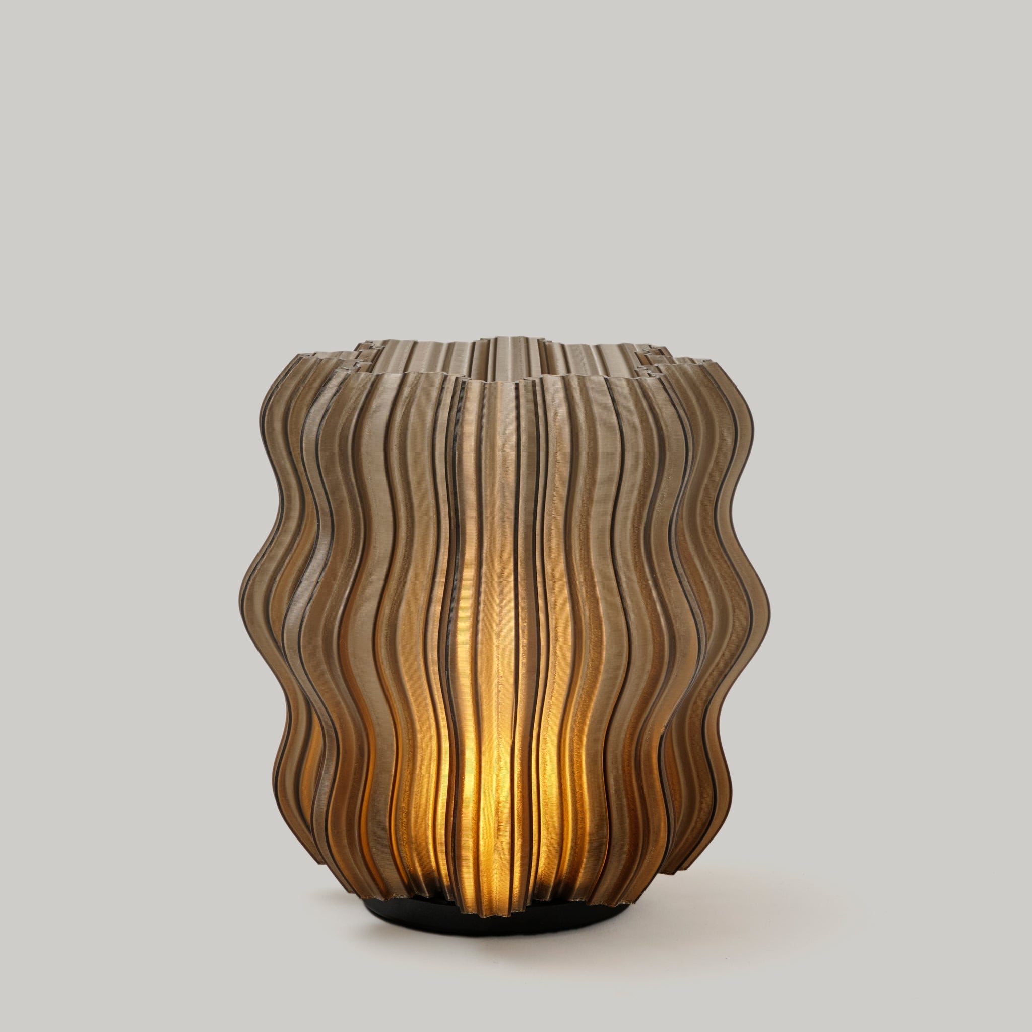 Wavy-patterned lamp with warm glow on a light gray background