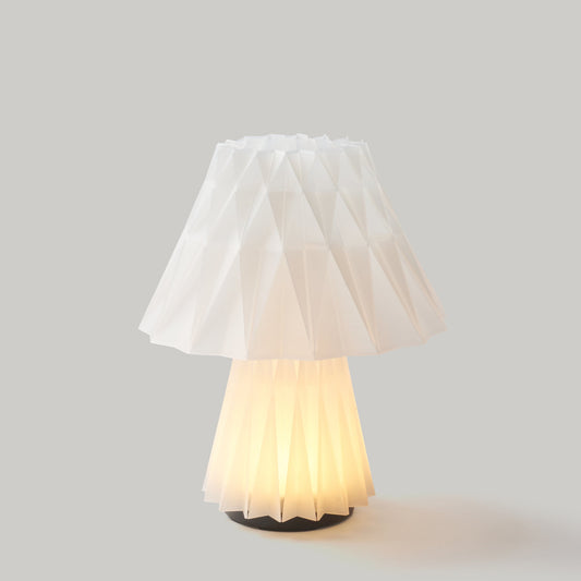 Table lamp with a white pleated shade on a gray background